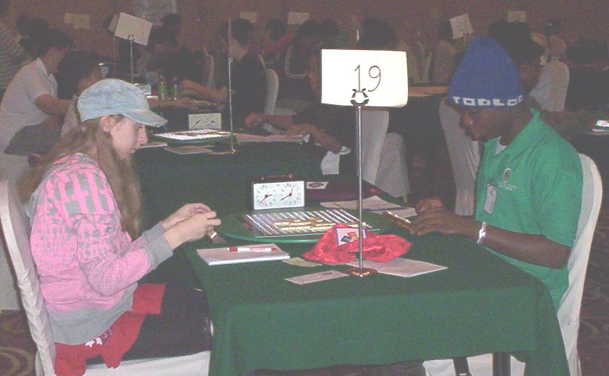 Jessica finished 11th out of 80 with 15 wins from 24 games, in the World Youth Scrabble Championships in Johor Bahru, Southern Malaysia. Here she is playing against another member of the hat brigade from Nigeria.